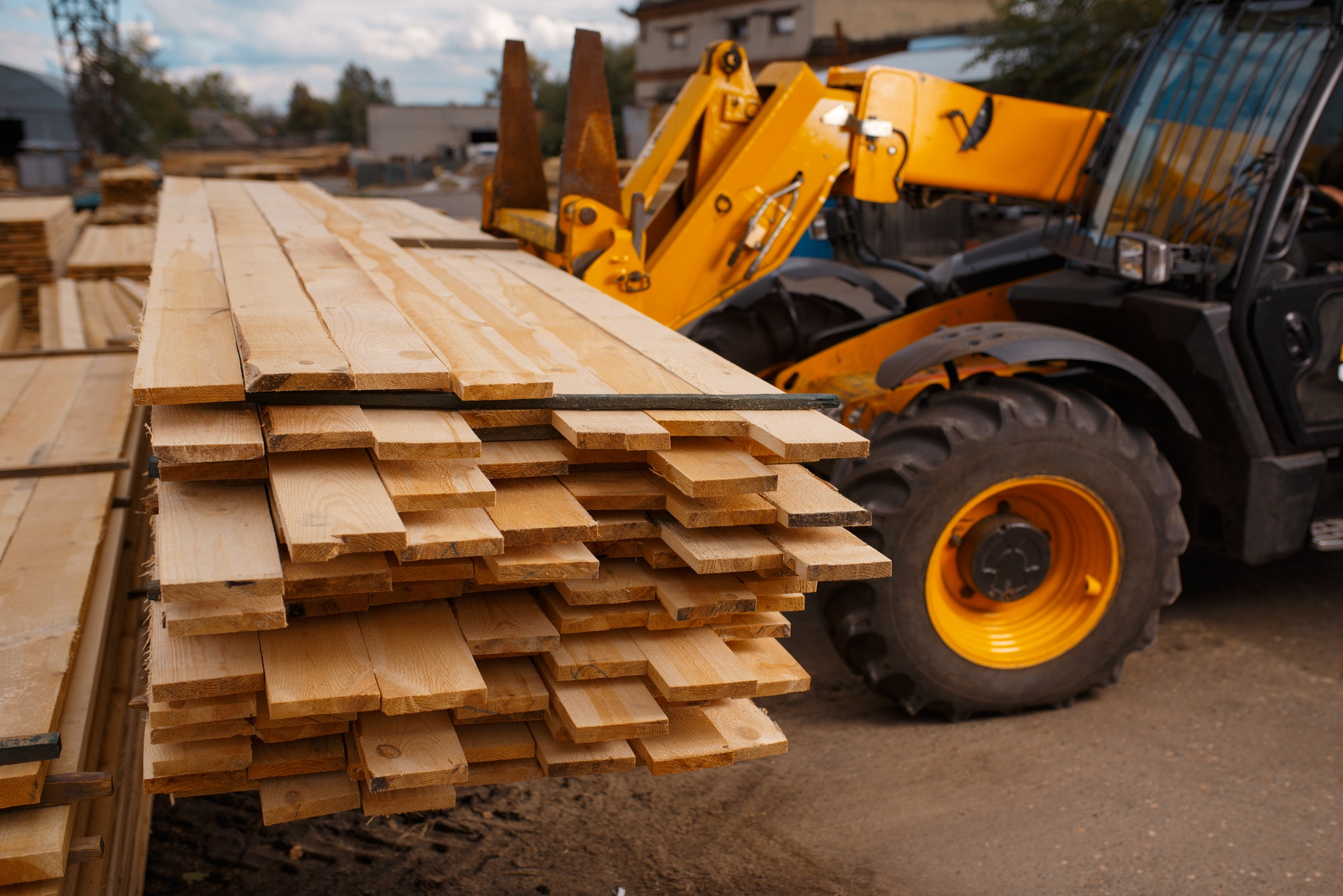 Forklift loads the boards in the lumber yard